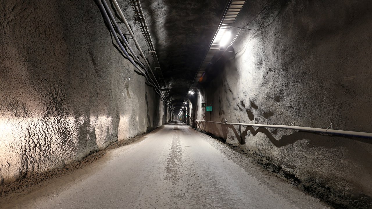 Archive photo from April 2020, not taken on the day of the decision: a lit, rock-walled driving tunnel inside the Onkalo spent-fuel repository at Olkiluoto, Finland