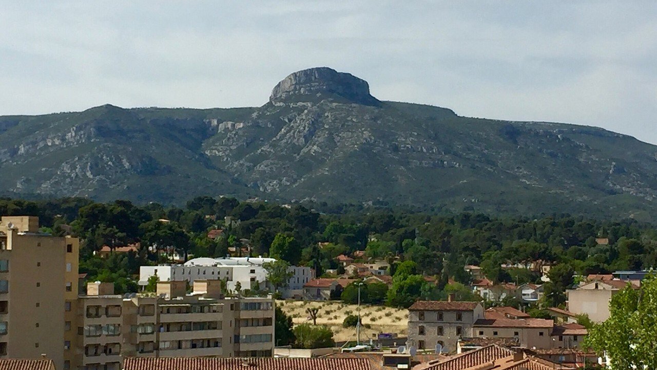 Stand-in, not a photo of this event: a May 2016 file photo of the Garlaban hill seen from Aubagne city center, Bouches-du-Rhône, France, with terracotta rooftops and green hills under a partly cloudy sky