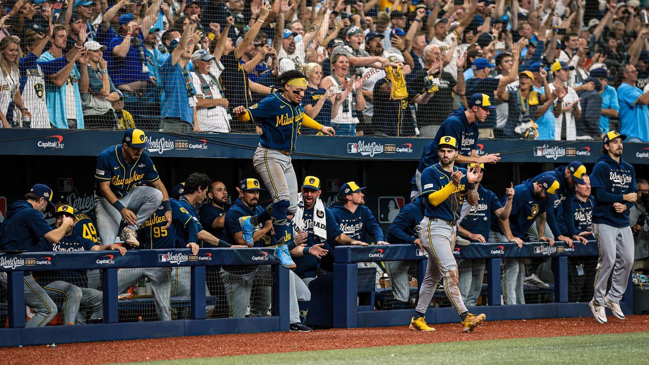 Photo posted on X by @Brewers: Milwaukee players leap from the visitors’ dugout at Tropicana Field as fans in Brewers gear cheer behind them after the World Series Game 3 win, Oct. 26, 2026