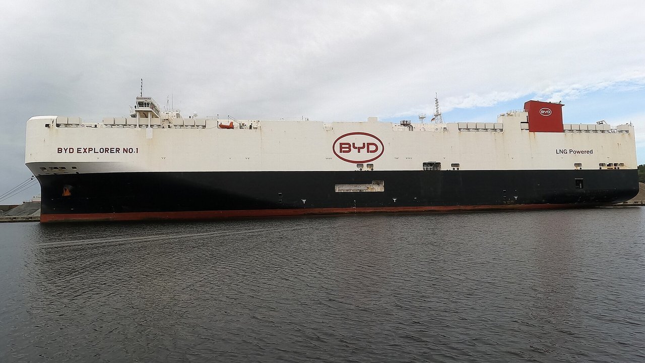 Stand-in, not a photo of this event: a September 2026 file photo of the car carrier BYD Explorer No.1, a white hull with a red BYD logo above a black and red waterline, moored at Wilhelmshaven, Germany, under a grey sky