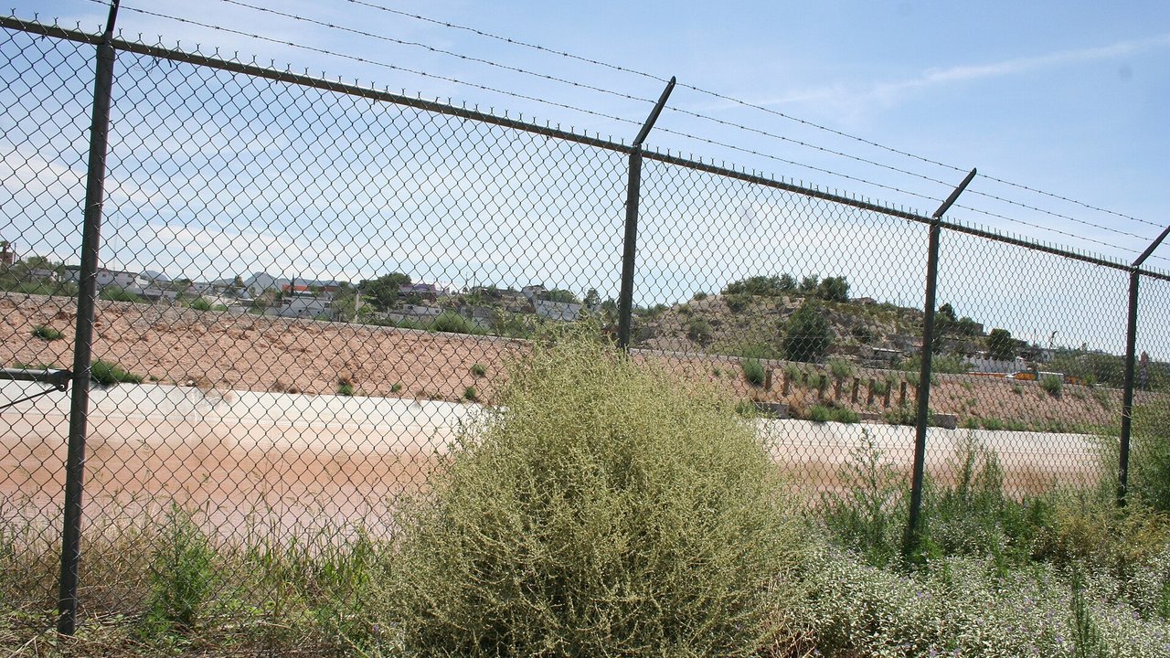 Stand-in, not a photo of this event: a chain-link fence topped with barbed wire beside desert shrubs at Onate Crossing in El Paso, Texas, in July 2008, with a concrete channel and a hillside of houses in Juárez, Mexico, beyond under a blue sky