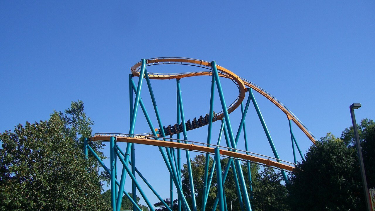 Stand-in, not a photo of this event: a 2007 file photo of the Goliath roller coaster at Six Flags Over Georgia, its orange track and teal steel supports curving in a high spiral against a blue sky above green trees, with a distant train of riders on the track