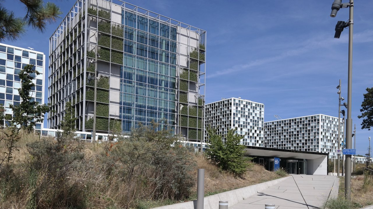 Stand-in photo from 2022, not of Thursday’s announcement: the glass towers of the International Criminal Court building in The Hague, behind dune grass under a blue sky