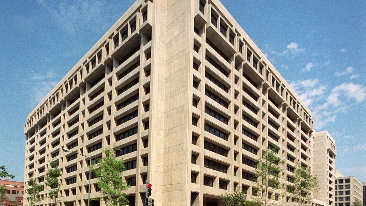File photo: the IMF headquarters building in Washington, a tall concrete office block with rows of windows under a blue sky