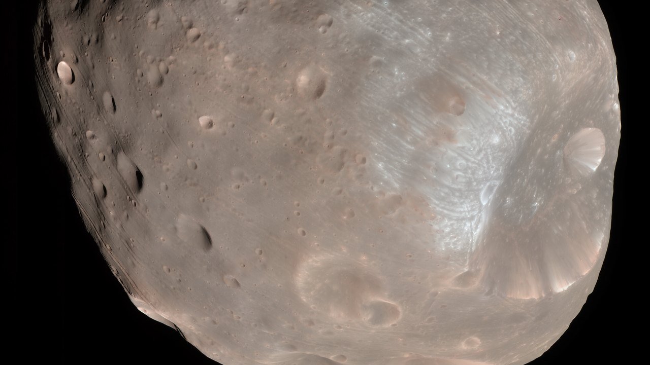 Stand-in, not a photo of this event: 2008 NASA color image of Mars’ moon Phobos, a lumpy gray-brown body pocked with craters and grooves against black space, with the large Stickney crater at lower right