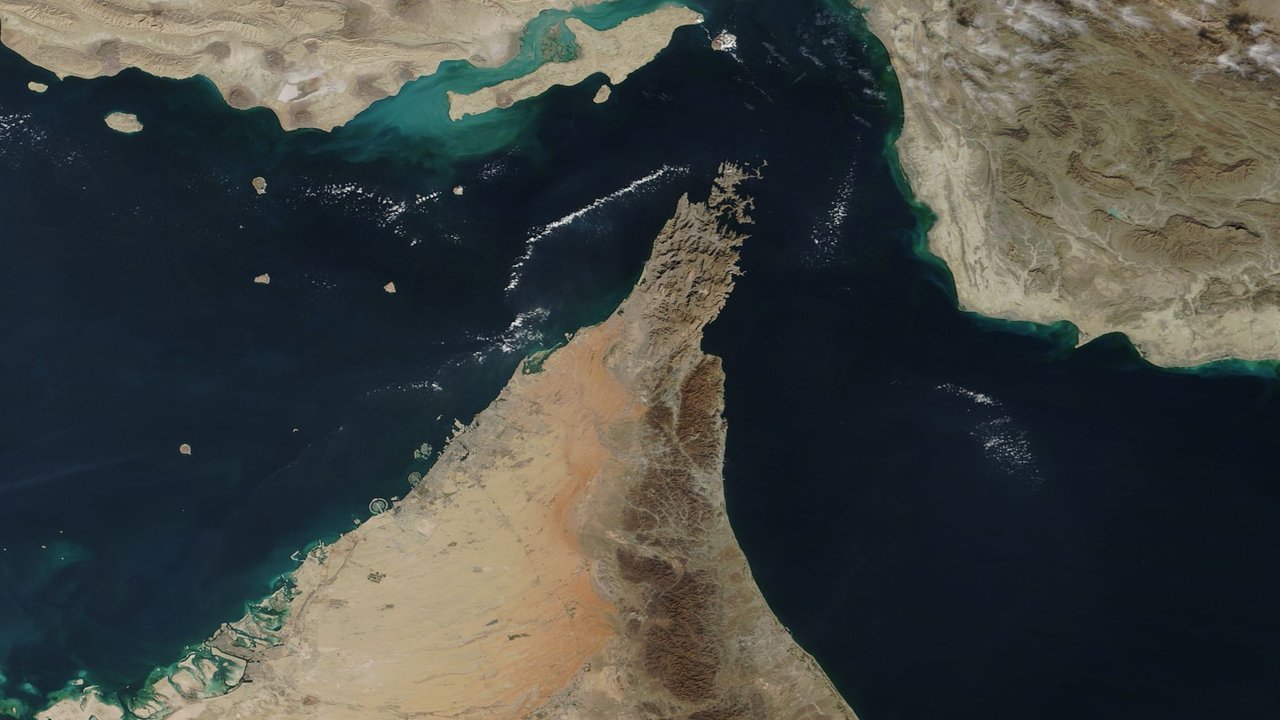 Stand-in, not a photo of this event: a NASA satellite view of the Strait of Hormuz, with Oman’s Musandam Peninsula reaching north between the Persian Gulf and the Gulf of Oman, Iran’s coast to the north and east, and Qeshm Island at top left (December 2018)