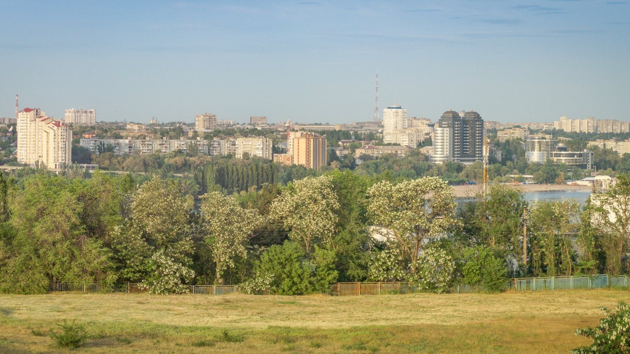 Stand-in, not a photo of this event: a pre-2018 file photo of the Zaporizhzhia skyline seen from a bridge, with trees in the foreground and apartment blocks beyond